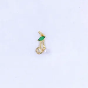 Close-up detail of a gold cherry charm featuring a micro-set zircon ball and green leaf.