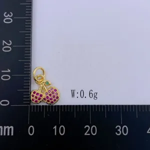 Detailansicht des süßen Kirsch-Anhängers mit rosa Strasssteinen und goldenem Metallaccessoire.