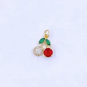 Detailed shot of gold-plated cherry pendant featuring green leaves, white and red cubic zirconia.