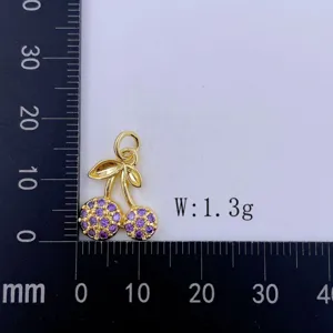 Goldener Kirschanhänger Detail mit lila besetzten Steinen und präziser Messskala.