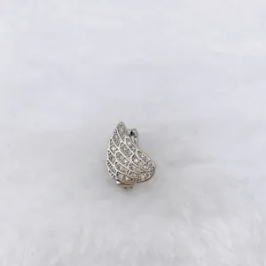 Detailed close-up shot of a sparkling silver wing charm jewelry accessory with crystal stones.