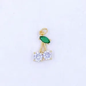 Detailed view of gold-plated cherry pendant featuring green and white cubic zirconia stones.