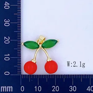 Close-up detail shot of a cute cherry pendant with red beads and green leaves on scale grid.