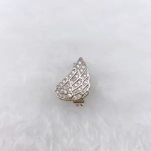 Detailed close-up shot of a silver-toned angel wing jewelry charm with shiny crystals.