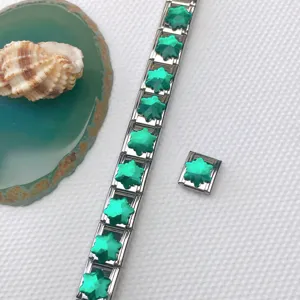Close-up detail of stainless steel Italian charm bracelet with green crystal star DIY links.