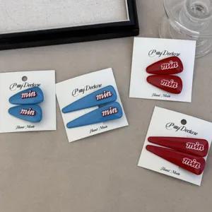 Rode en blauwe haarspelden met cartoonletters detailweergave, stijlvolle haaraccessoires.
