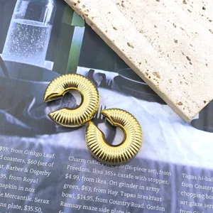 Gold ribbed C-shaped ear clips for women, vintage geometric non-piercing earrings detail.