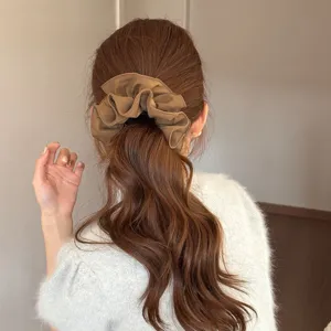 Bruine stoffen haarrekkers voor vrouwen, elegante lage paardenstaart hoofdaanzicht.