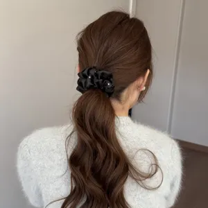 Black satin hair scrunchie detail view, elegant rhinestone sparkle, daily ponytail accessory.