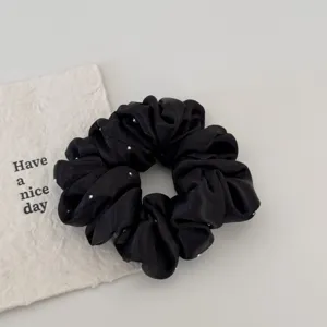 Black satin rhinestone hair scrunchie detail view, elegant hair accessory for women.