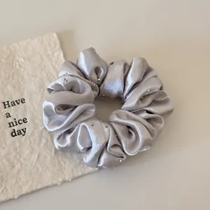 Silver satin rhinestone hair scrunchie detail view, elegant shiny hair tie for women ponytails.