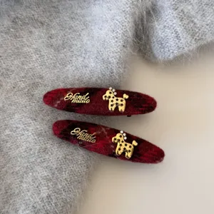 Pinces à cheveux à carreaux rouges avec caniche doré et texte handmade pour l'hiver.