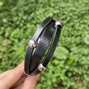 Nahaufnahme des mehrschichtigen schwarzen Lederarmbands mit Metallperlen im Detail.