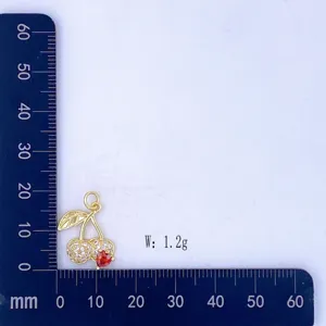 Detailed view of gold cherry pendant with red heart stone and clear cubic zirconia stones.