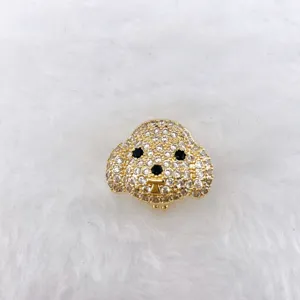 Close-up detail of sparkling gold puppy head rhinestone charm for cute DIY jewelry making.