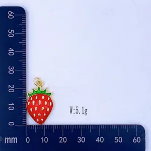 Cute strawberry pendant charm with red enamel gold trim and measurement scale background.