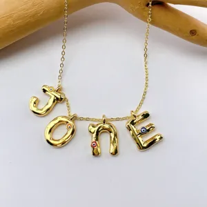 Gold plated letter necklace with evil eye pendants, stylish copper jewelry accessory.