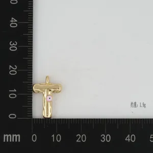 Gold plated letter T pendant detail with pink evil eye accent and scale board display