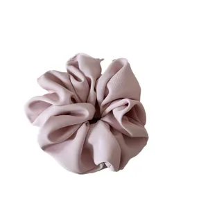 Elegant pink satin scrunchie for women, soft hair tie and pony tail holder for daily styling.