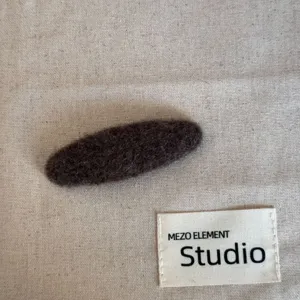 Vue détaillée de la pince à cheveux marron duveteuse, texture peluche douce pour l'hiver.
