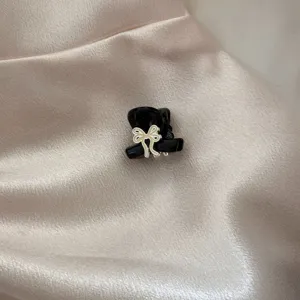 Exquisite black metal hair claw with bow detail, perfect for styling bangs and daily hair.