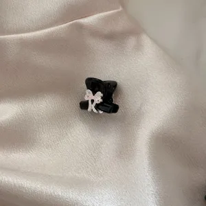 Black alloy mini hair claw clip with a cute pink bow, perfect for styling bangs and hair.