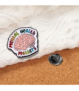 Primo piano dettagliato della spilla smaltata cervello mental health matters con farfalla.