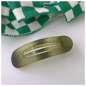 Pince a cheveux degrade vert mat detail, style minimaliste, accessoire de coiffure elegant.