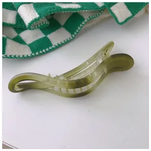 Vue détaillée d'une pince à cheveux mate dégradée verte, au design minimaliste et élégant.