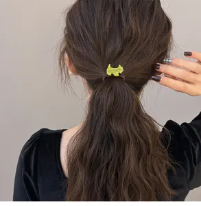 Primer plano de la bonita goma de pelo de acetato verde con diseño de perrito y elástico.