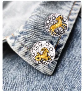 Nahaufnahme von Retro Sternzeichen Metall Abzeichen Pins mit Widder und Steinbock.