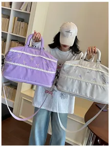 Detailed view of large capacity travel duffel bag with cute lace bow embroidery and dual handles.