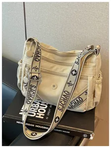 Λεπτομερής όψη της casual τσάντας χιαστί από καμβά με πολλαπλές τσέπες και φαρδύ ιμάντα.