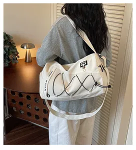 White canvas travel duffel bag with bungee cords, casual gym and sports training shoulder bag.
