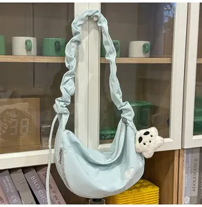 Light blue hobo cloud shoulder bag with cute plush pendant and bow embroidery for women daily.
