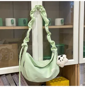 Light green canvas cloud bag with ruffled strap, casual crossbody shoulder bag detail view.