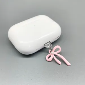 Nahaufnahme Detail eines süßen rosa Schleifen-Staubschutzsteckers mit Perlenakzent am Ladeanschluss.