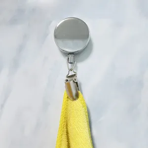 Detailaufnahme des metallischen ausziehbaren Ausweishalters mit Handtuchklemme und gelbem Tuch.