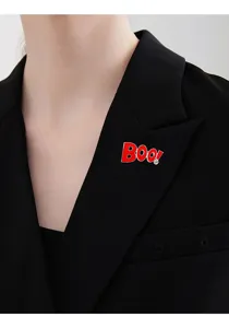Halloween Boo letter enamel brooch detail shot, stylish red crystal lapel pin accessory.