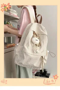 Detailed view of the cute beige plaid student backpack with plush doll pendant and drawstring.