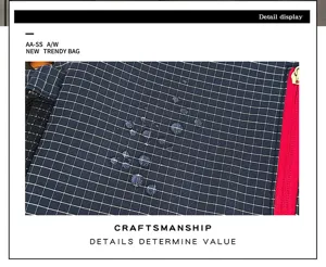 Primer plano del tejido impermeable de la mochila de cuadrícula con cremallera roja.