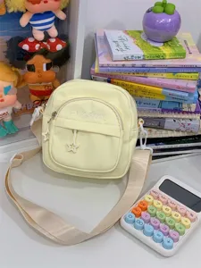 Light yellow canvas crossbody bag detail, casual small shoulder bag with front pocket & star zip.