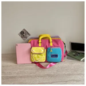 Dettaglio borsone da viaggio colorblock con design multi-tasche e stile dopamina vivace.