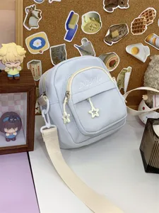 Detailed view of the light blue casual crossbody bag featuring cute star zipper pulls and pockets.