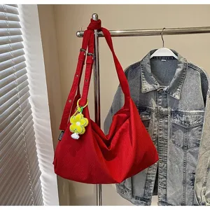 Sac bandoulière hobo en toile rouge avec charm fleur, grand format décontracté chic.