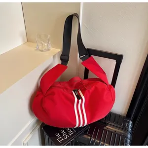 Red sports duffel bag detail, casual travel shoulder bag with white stripes and wide strap.