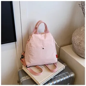 Pink canvas casual backpack detail, featuring top handles, adjustable straps and front pocket.