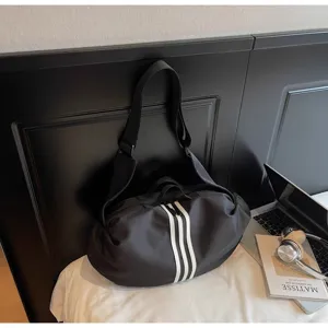 Detail view of black travel duffel bag with white stripes, sports fitness design.