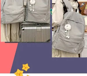 Grey casual nylon school backpack detail view featuring cute fluffy pendant and front pocket.
