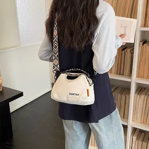 Modische Segeltuch Muscheltasche für Damen mit breitem Gurt und Tragegriff für den Alltag.
